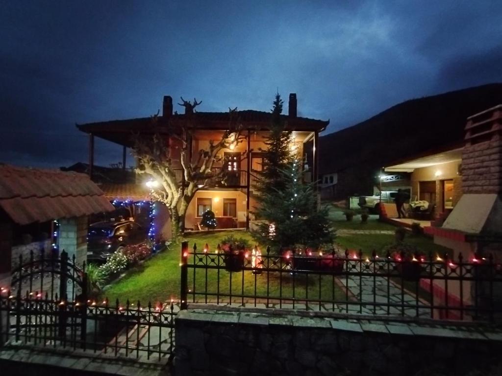 une maison avec des lumières de Noël devant elle dans l'établissement Guesthouse Mythos, à Órma