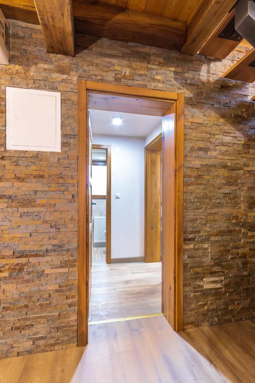 an open door into a room with a brick wall at Apartment Stone and Wood in Cetingrad