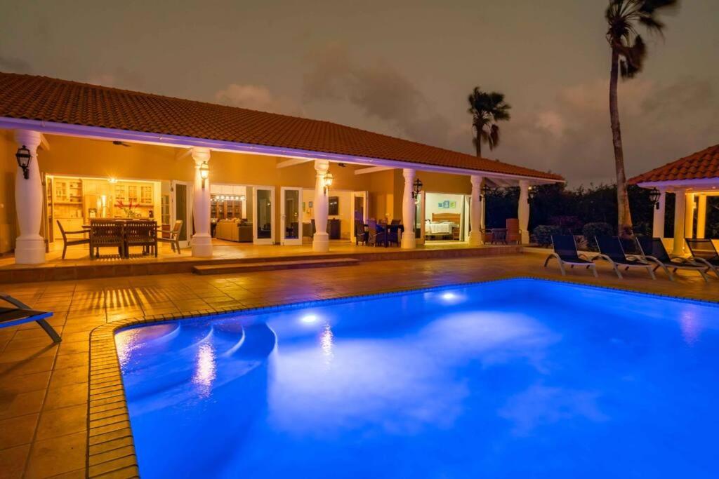 una piscina frente a una casa por la noche en Ocean Front VillaDelMar-Beach Access-Private Pool-10 Guests- en Willibrordus