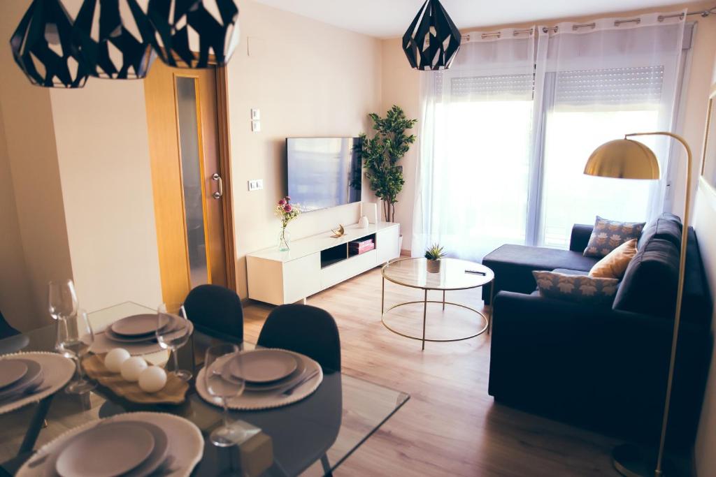 a living room with a table and a couch and a tv at Apartamento Centro Castellón con Parking 2 in Castellón de la Plana