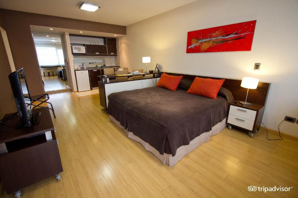 1 dormitorio con 1 cama con almohadas de color naranja en Uriburu 1756 by Ayres Apartments Recoleta en Buenos Aires