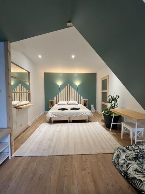1 dormitorio grande con 1 cama y 1 mesa en La cabane verte - une nuit pour deux, en Verneuil-sur-Vienne