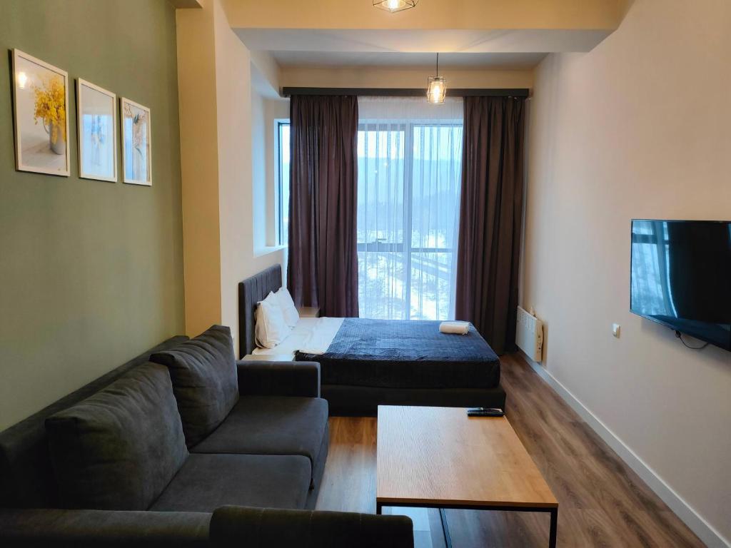 sala de estar con sofá y cama en Tsaghkadzor Kechi Apartment 136, en Tsaghkadzor