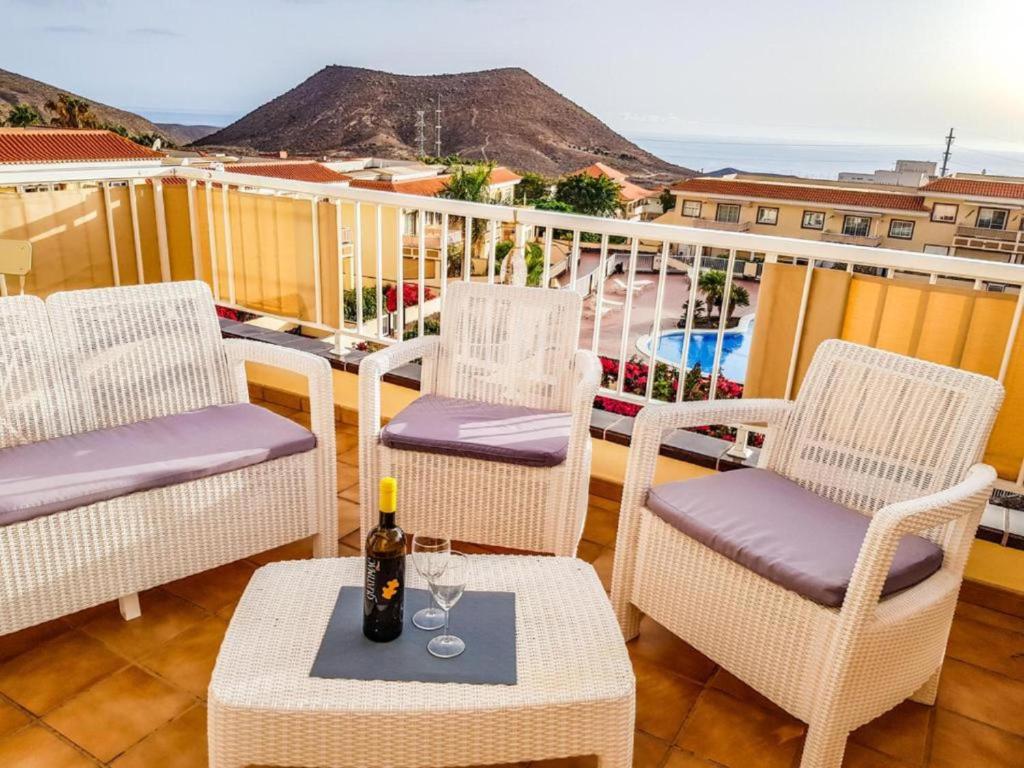 a balcony with chairs and a table with a bottle of wine at Lovely Apartment in Tenerife South in Chayofa