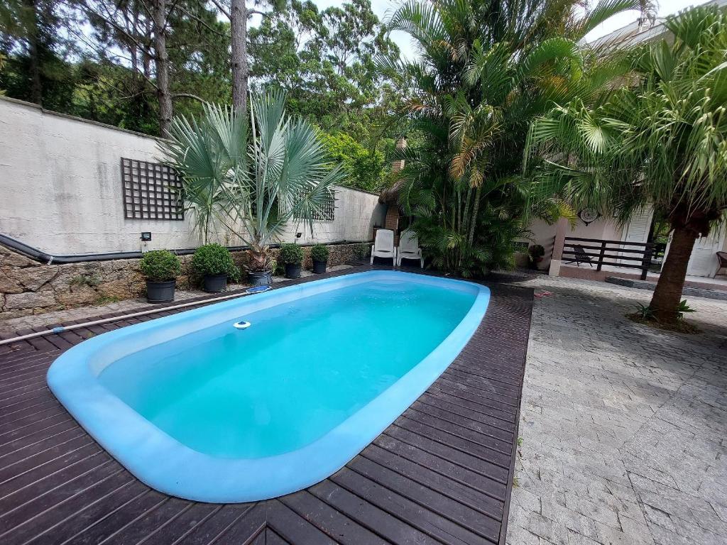 una gran piscina azul en una terraza de madera en Loft Barra da Fortaleza com Piscina, en Florianópolis