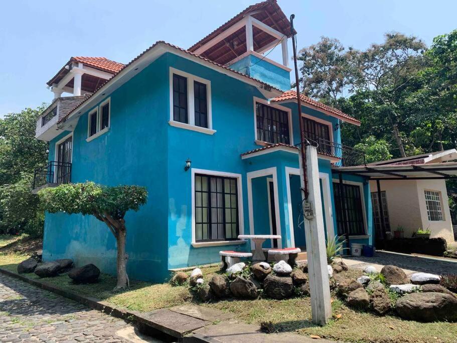 a blue house with a tree in front of it at Casa 2 a 5 min del Irtra in Retalhuleu