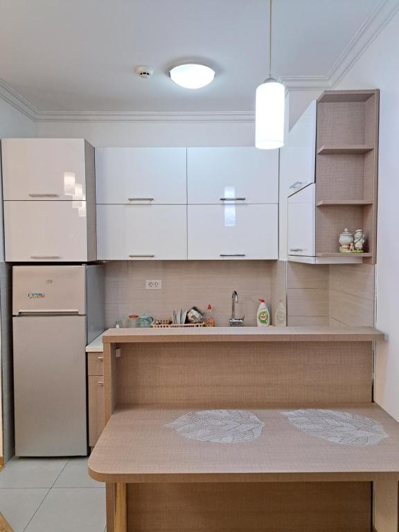 a kitchen with white cabinets and a counter top at Apartment Bono 2 City Kvart in Podgorica