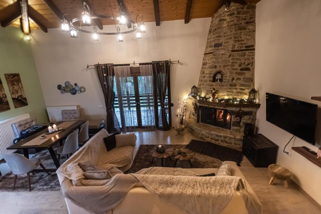 sala de estar con sofá y chimenea en Ονειροπαγιδα en Karpenísion
