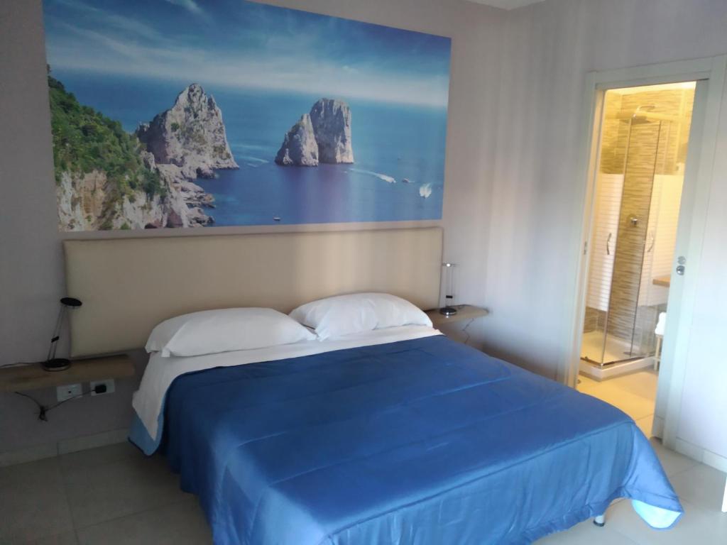 - une chambre dotée d'un lit bleu et d'une peinture murale dans l'établissement Mediterraneo, à Boscoreale