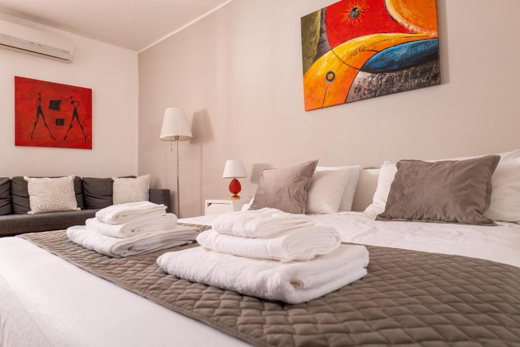 um quarto com uma cama com toalhas brancas em Madinah apartments em Palermo