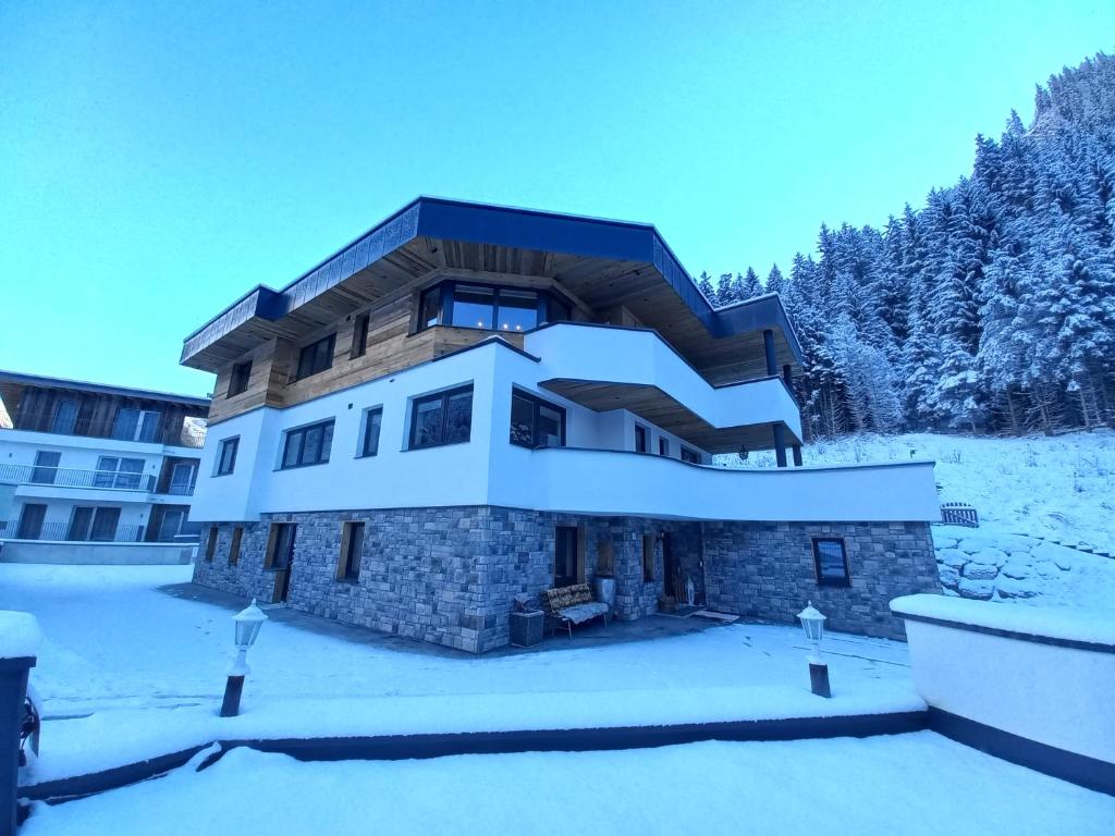 ein Haus im Schnee mit Schnee in der Unterkunft Chasa Patria Apartments in Ischgl