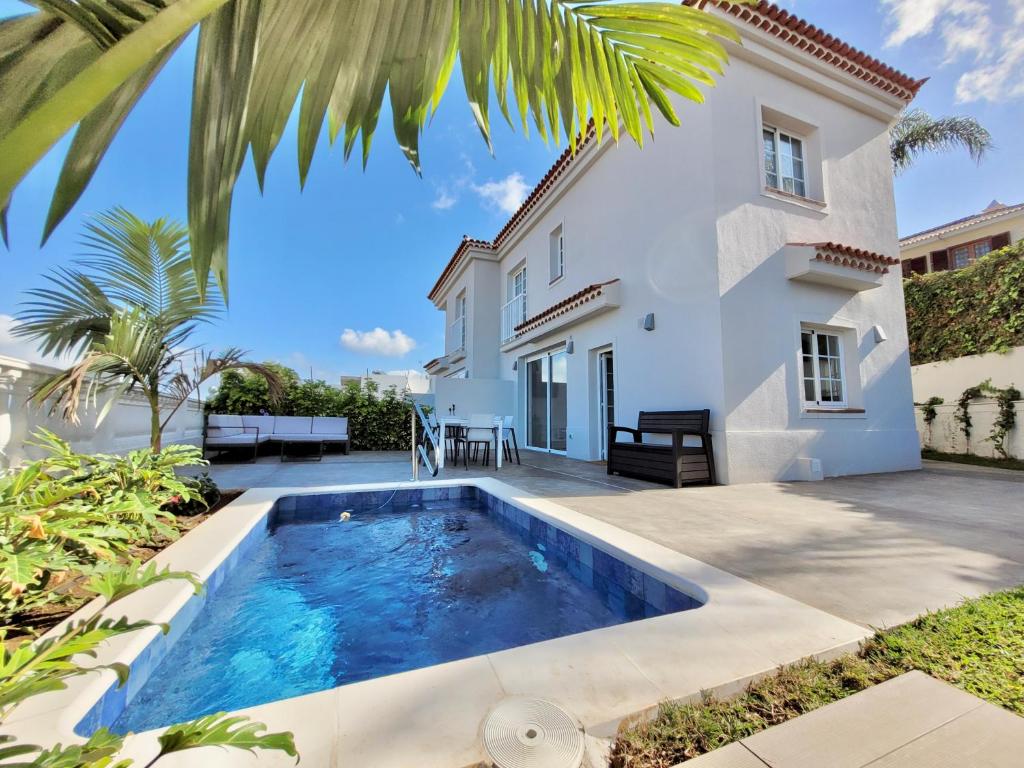 a villa with a swimming pool in front of a house at Villa Trevina in Puerto de la Cruz