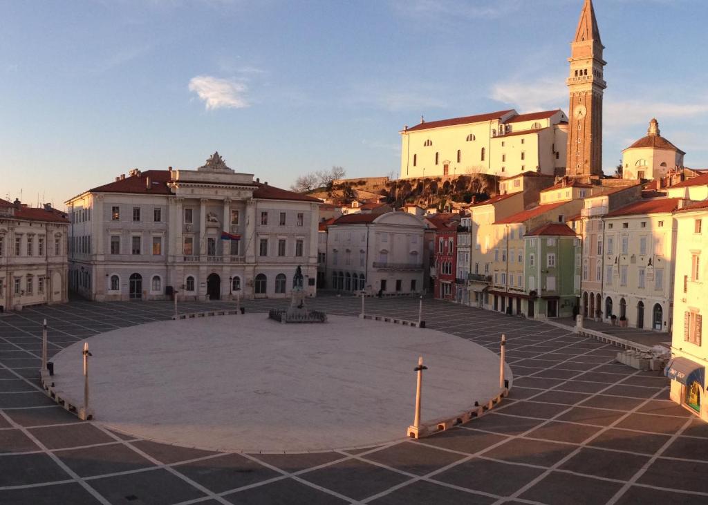 a city square with a clock tower and buildings at Apartment Marciana in Piran