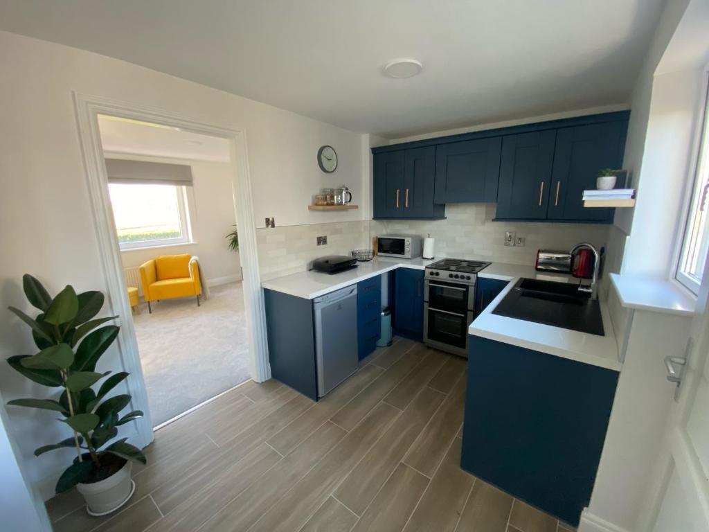 a kitchen with blue cabinets and a yellow chair at Sunny Hill View in Lahinch
