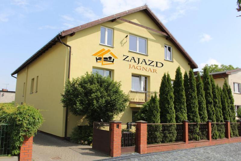 a yellow building with a fence in front of it at Zajazd Jagnar in Trzcianka