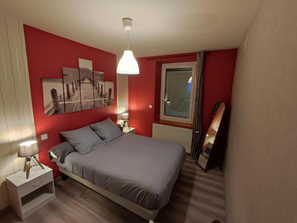 a red bedroom with a bed and a window at Appartement 5 personnes à deux kilomètres des pistes in La Bresse