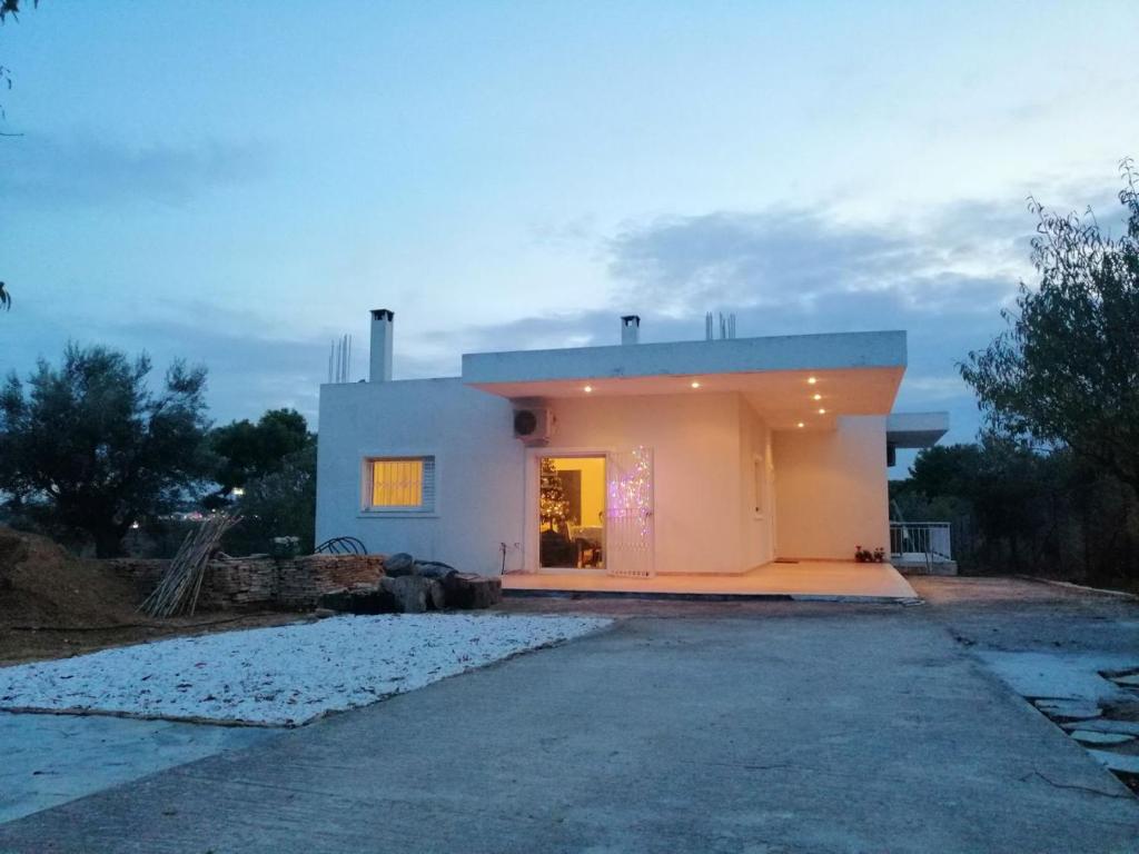 a white house with a driveway in front of it at CostasFarmhouse, Pallini, Near Athens Airport in Pévka
