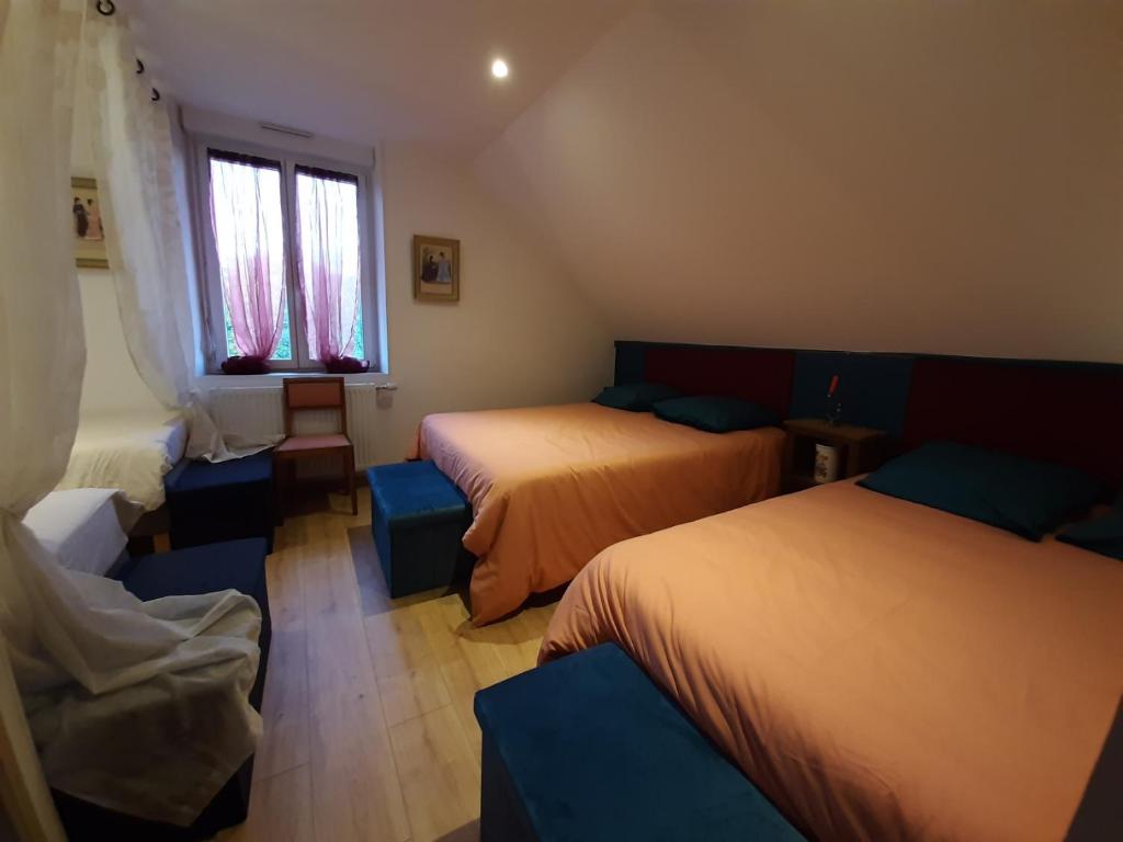 Habitación con 2 camas, sofá y ventana en LE DEUX GAULLE, en Le Mêle-sur-Sarthe