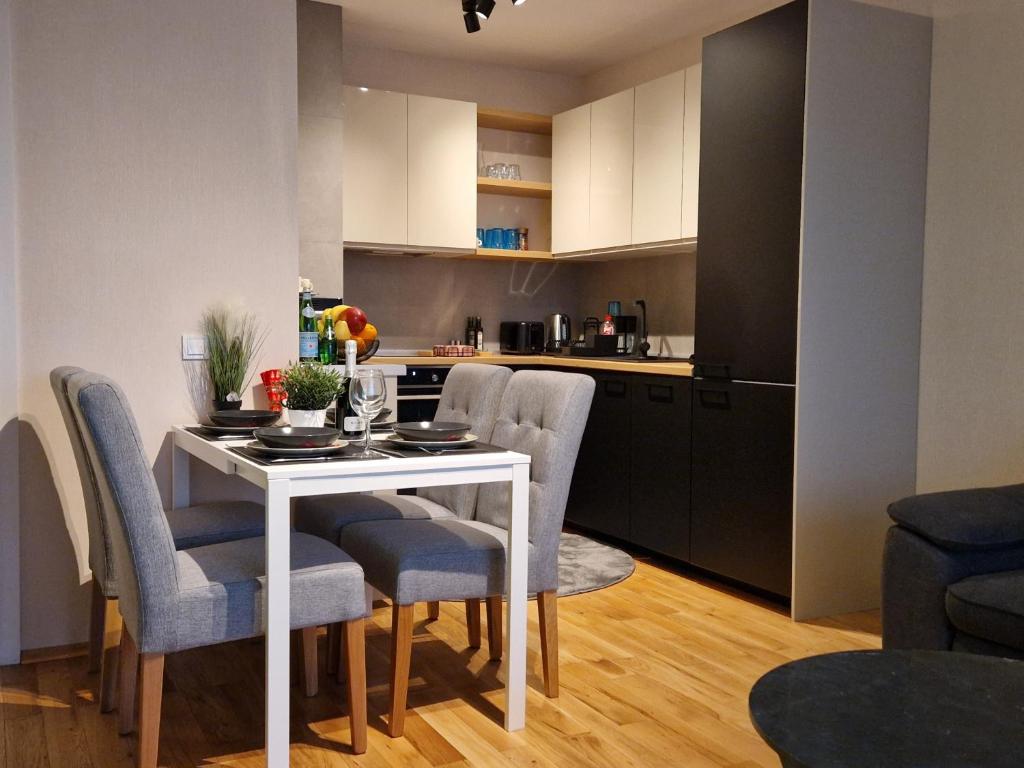 a kitchen and dining room with a white table and chairs at Апартамент RESORT SENSATION 3 in St. St. Constantine and Helena