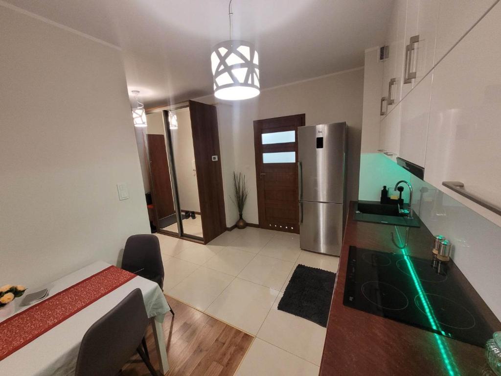 a kitchen with a stainless steel refrigerator and a table at Apartament Grunwaldzka in Olecko