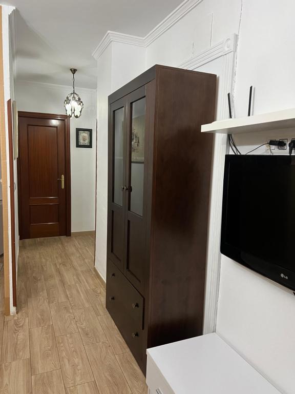 - un salon avec une télévision et un meuble marron dans l'établissement El Torreón 3, à Lora del Río