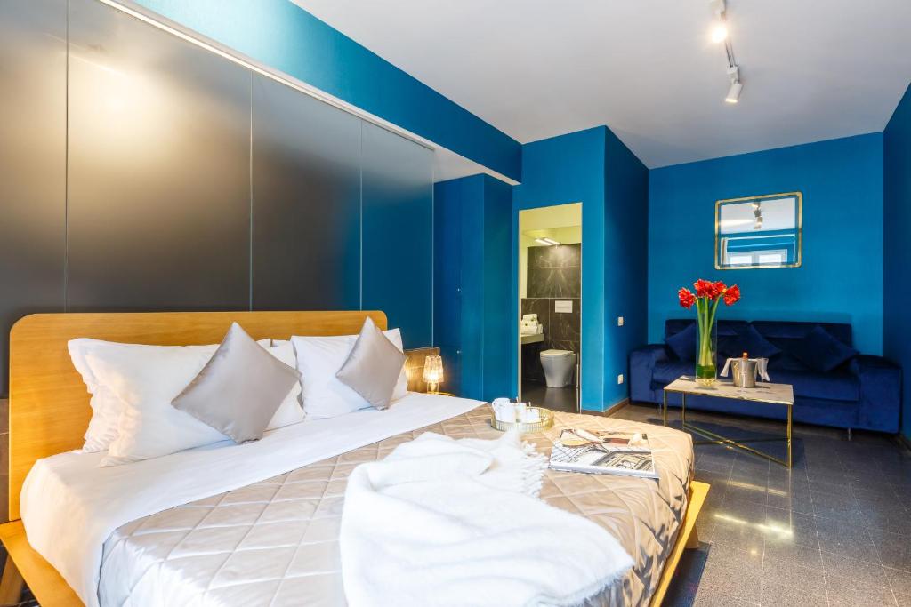 um quarto com paredes azuis e uma cama grande em Dimora Doria d'Angri em Nápoles