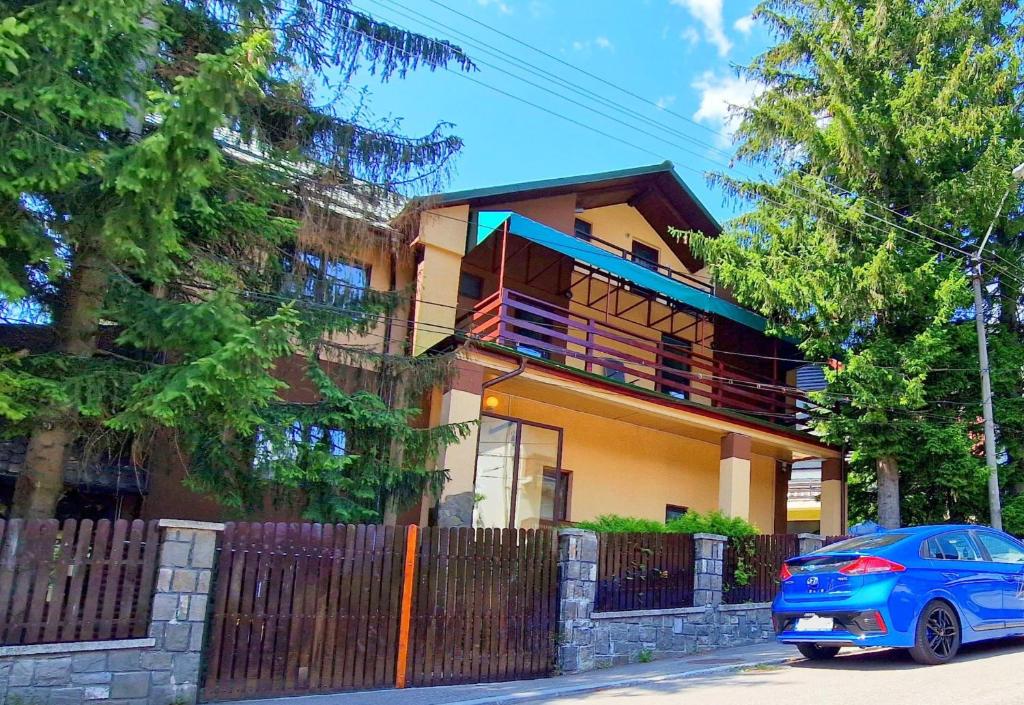 a blue car parked in front of a house at Casa cu Brazi in Buşteni