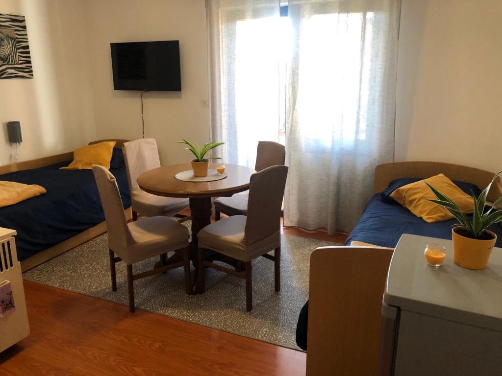 uma pequena sala de estar com uma mesa e uma cama em STUDIO APARTMAN MARINJAK em Belišće