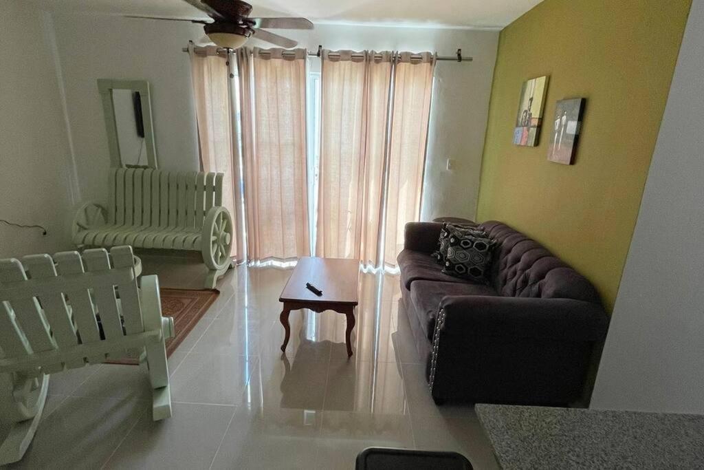 ein Wohnzimmer mit einem Sofa und einem Tisch in der Unterkunft Nice Apt in punta cana 7 minutes from airport , 10 minutes from the beaches in Punta Cana