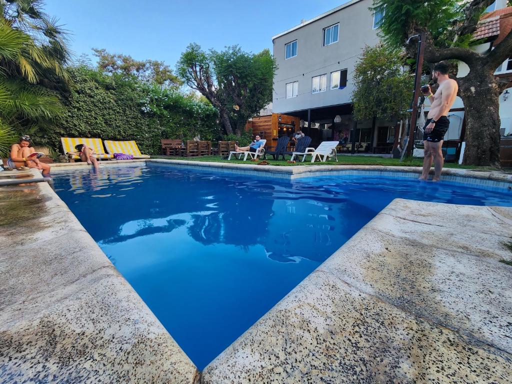 a man standing next to a swimming pool at Gorilla Hostel in Mendoza