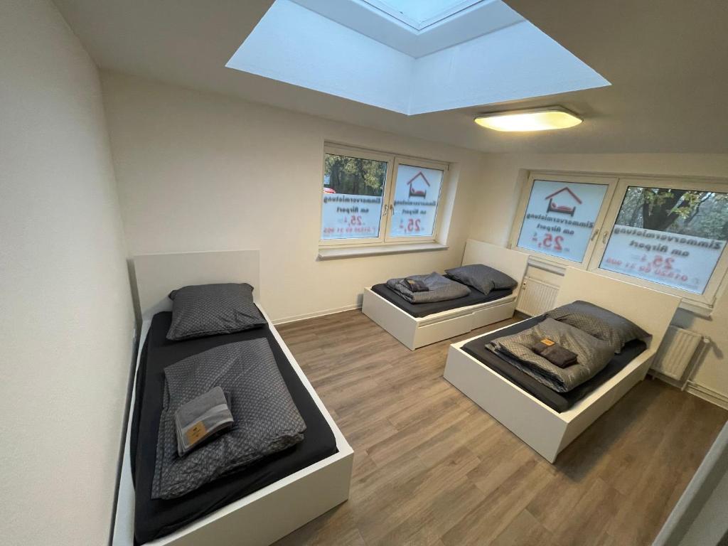 twee bedden in een kamer met een dakraam bij Zimmervermietung Am Airport in Bremen
