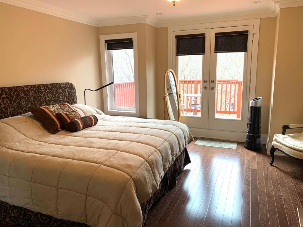 a bedroom with a bed and a couch and windows at Luxury Home - Upper Toronto Beaches in Toronto