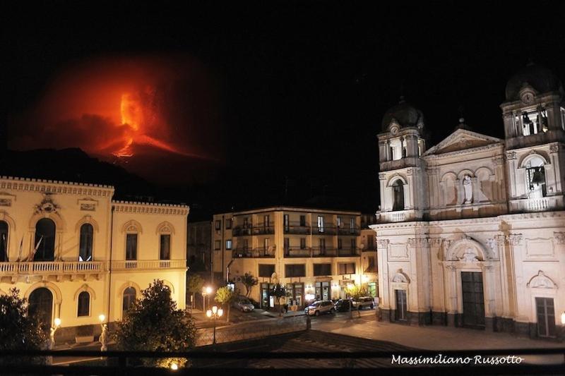an old building with a fire in the background at night at La Valle dell'Etna in Zafferana Etnea