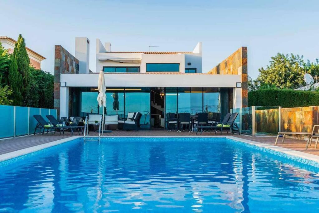 uma casa com piscina em frente a uma casa em Luxurious VILLA 6 BD W/heated pool , GOLF, Beach em Almancil