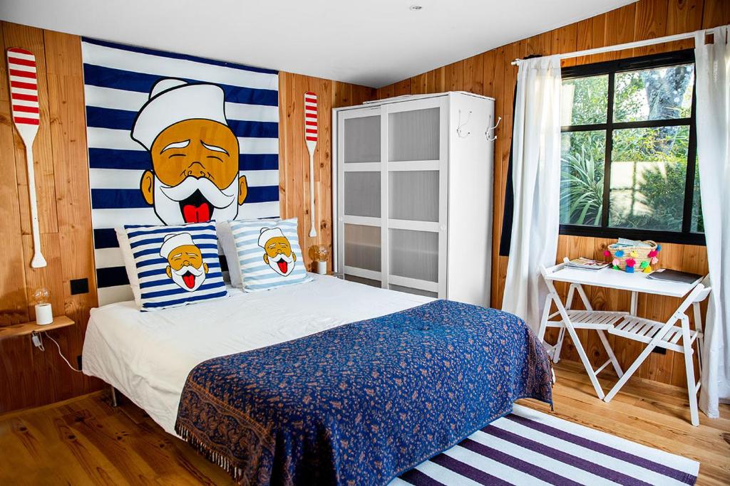 een slaapkamer met een bed met een chef-kok aan de muur bij Beach House in Lège-Cap-Ferret