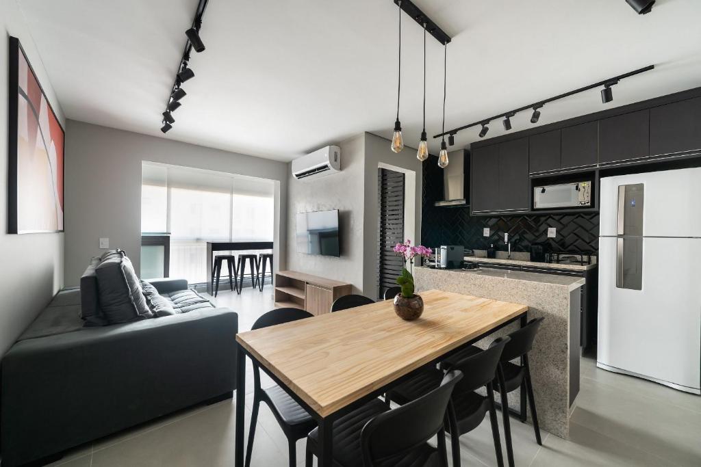 a kitchen and living room with a table and a couch at OA12 Aconchego próximo ao Parque Augusta in Sao Paulo