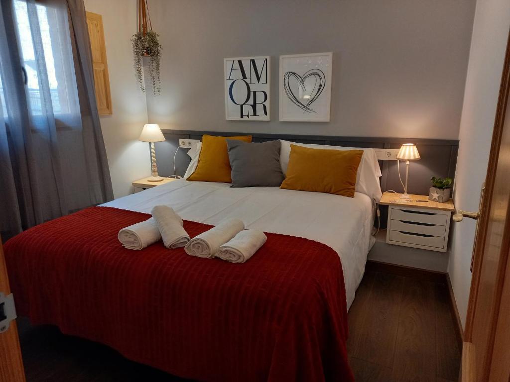 a bedroom with a large bed with two towels on it at Lo corralet in Torre del Compte