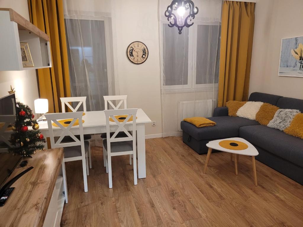 a living room with a table and a couch at APARTAMENT-SADOWA in Elblag