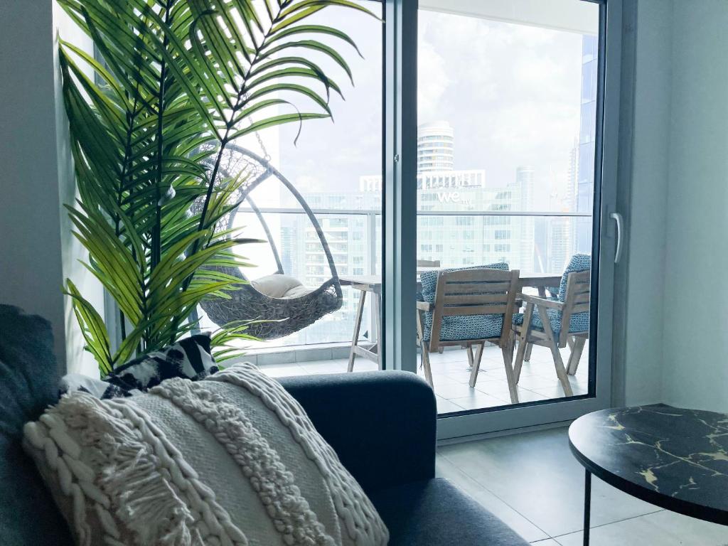 Midtown Tel Aviv Luxury Apartment في تل أبيب: غرفة معيشة بها أريكة وزرع