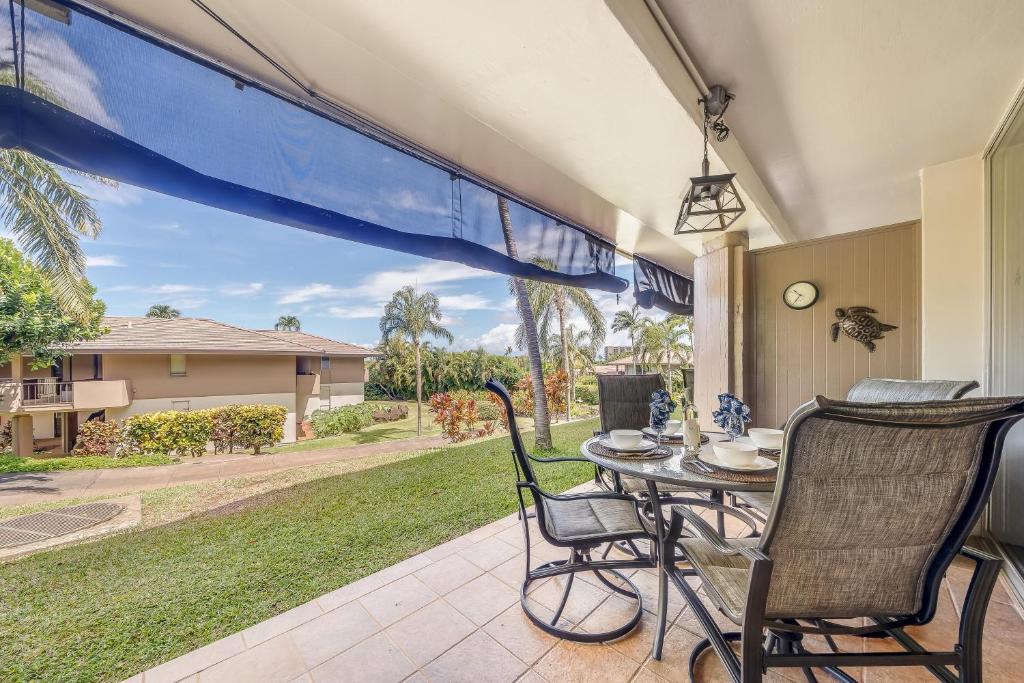 a patio with a table and chairs and a view of a yard at Eldorado D106 in Kahana