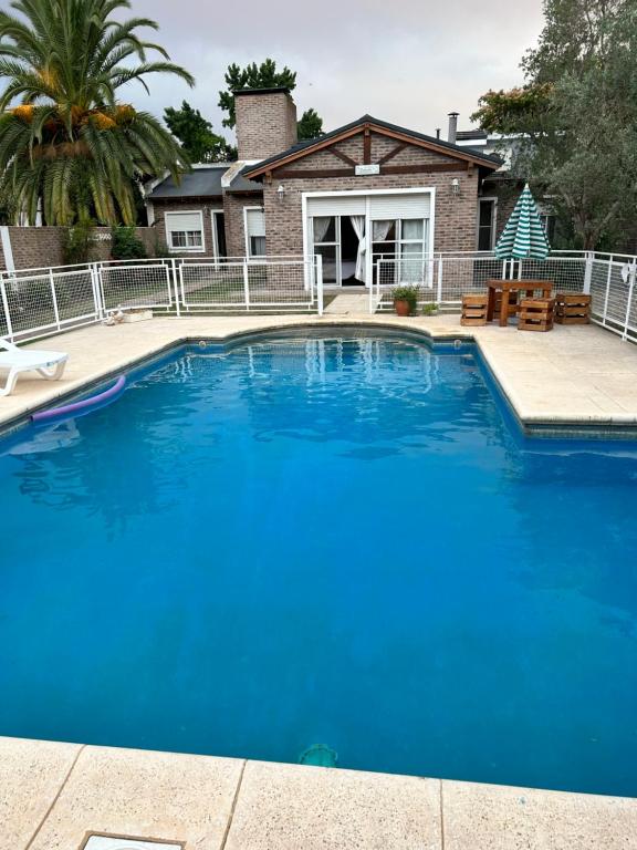 una gran piscina azul frente a una casa en Los abuelos en San Antonio de Areco