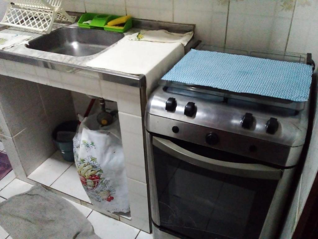 a kitchen with a stove and a sink at Kitinete em Itanhaem in Itanhaém