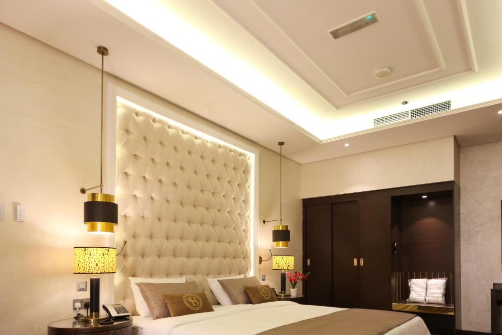 a bedroom with a large bed and a large headboard at The B Premiere Hotel in Doha