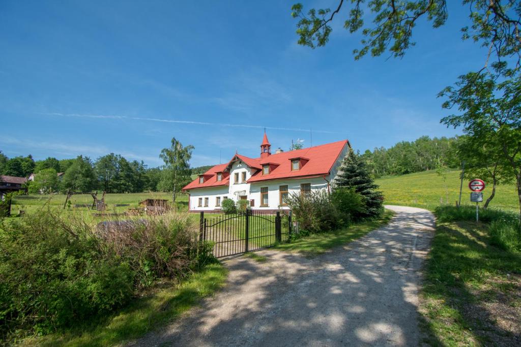 una casa blanca con techo rojo en un campo en Horská chata Medika, en Horní Maršov