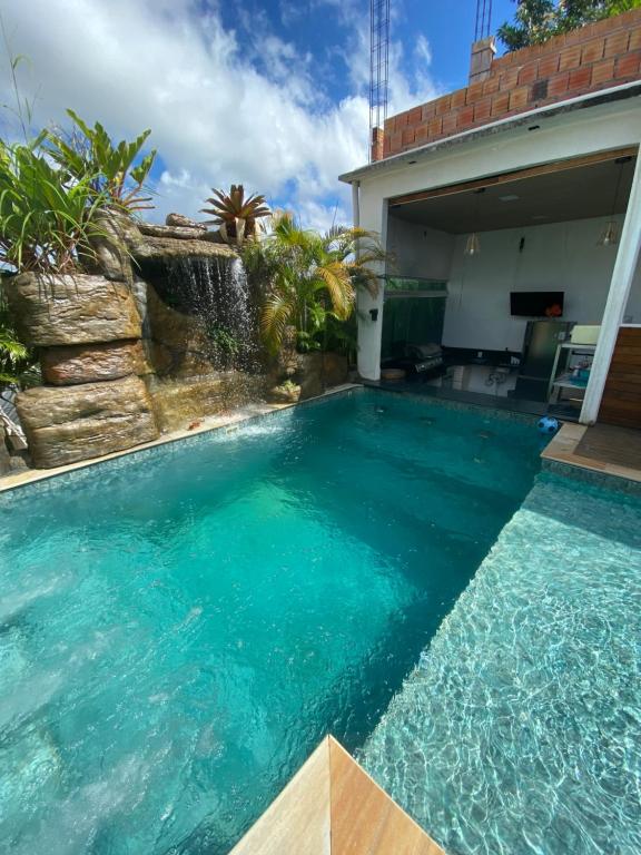 a swimming pool in a backyard with blue water at Super Casa Piscina Com Cascata in Manaus