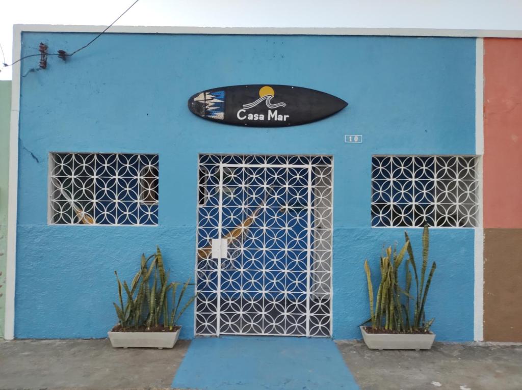 a blue building with a surfboard on the wall at Casa Mar in Baía Formosa