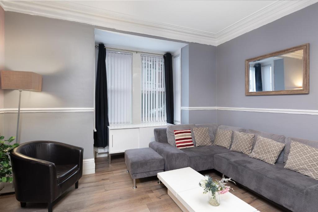 uma sala de estar com um sofá e uma cadeira em City Centre Large Luxury Rooms Free Parking em Gateshead