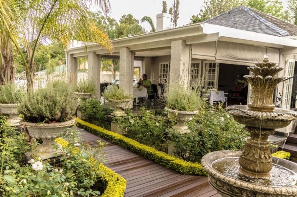 a house with a garden in front of it at Touch of Class Guest House in Pretoria