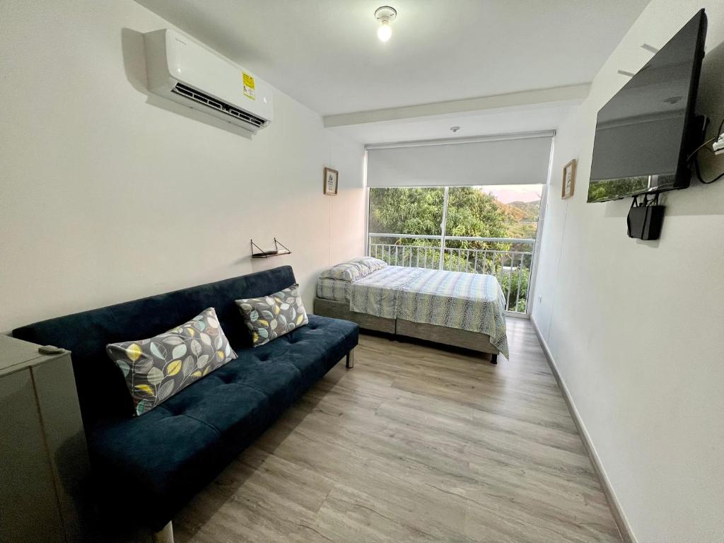 a living room with a couch and a bed and a window at APARTAMENTO NUEVO, MODERNO y MUY CÓMODO - 409 in Santa Marta