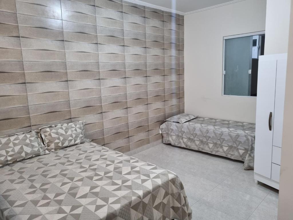 Apartamento lugar de Paz في سلفادور: غرفة نوم بسريرين وتلفزيون فيها
